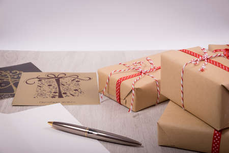 Christmas gift and white open xmas card over a wood backgroundの写真素材