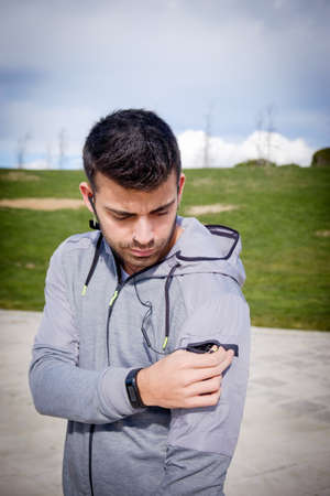 One young caucasian athletic man is preparing before running in a city park in winter.の写真素材