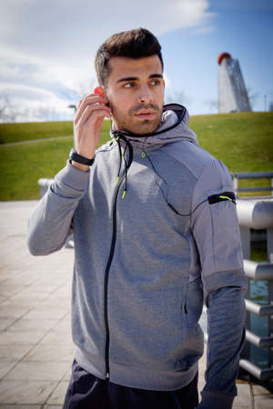 One young caucasian athletic man is preparing before running in a city park in winter.の写真素材