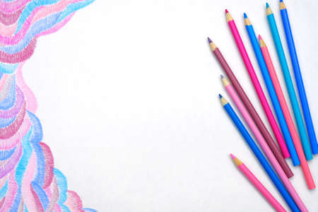 Blue and pink color pencils on white background with abstract pictureの写真素材