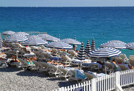 Chairs and umbrellas on beach in Nice, city in French rivieraの写真素材