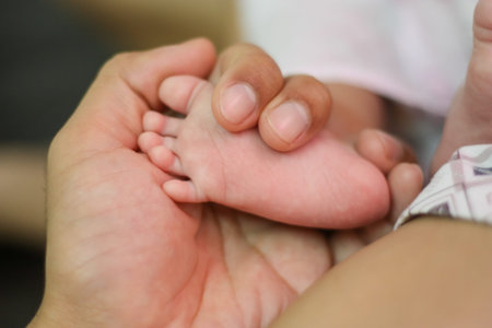 Close up of new born baby feet in parents hand. Concept for love,happy family and parenthood.