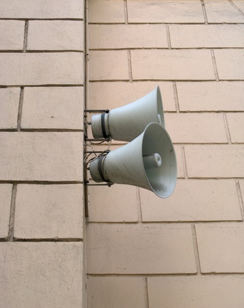 Two speakers are installed on a wall of a buildingの写真素材