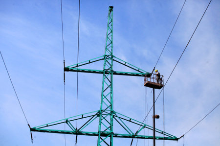 Repair works at the high-voltage power tower outside the city, elevator for high-rise works, closer...
