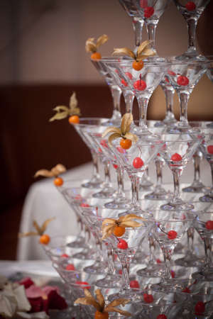 pyramid of glasses, cherry and winter cherry in the glass, rose petals in the backgroundの写真素材