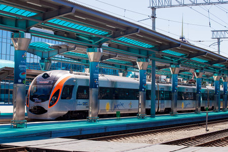 Modern passenger train stands on new railway station platform with canopy, Donetsk, summer 2012,...