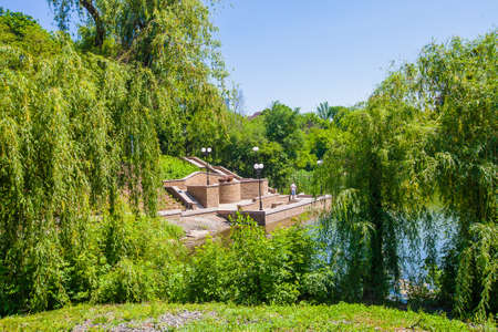 Stairs and parapet on the shore of the pond in the city parkの写真素材