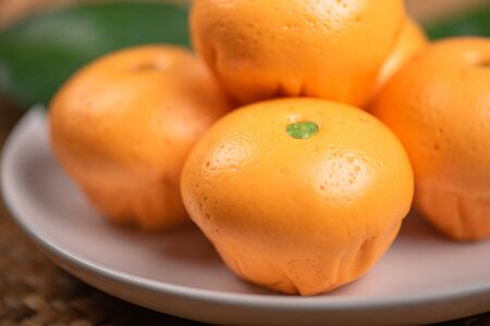 Cute pork buns in a form of oranges
 on white plate, close-upの写真素材