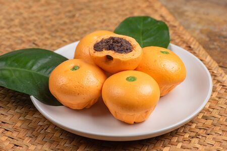 Cute pork buns in a form of oranges on white plateの写真素材