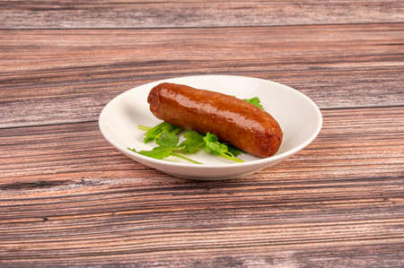 The sausage on the plate is on the wooden tableの写真素材