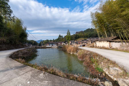 Beautiful mountain village, with lake, blue sky, house and grasslandの写真素材