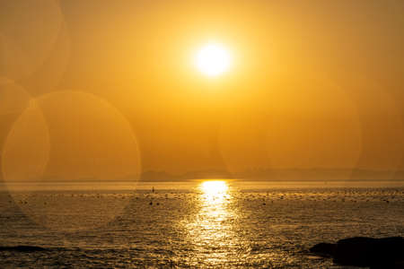 The sea under the setting sun is golden, and the sun is like an egg yolkの写真素材