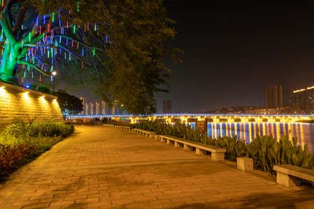 In the city at night, colorful lights are reflected in the water of the riverの写真素材