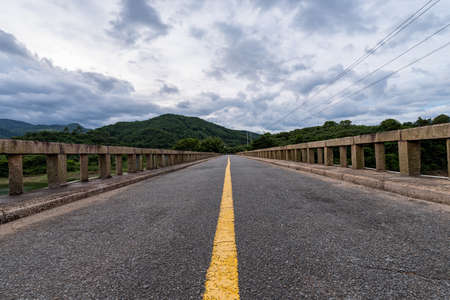 The road leading to the distance on a cloudy dayの写真素材
