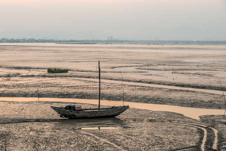 At dusk, abandoned fishing boats docked in the shoalの写真素材