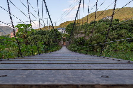 A sling bridge over a country riverの写真素材