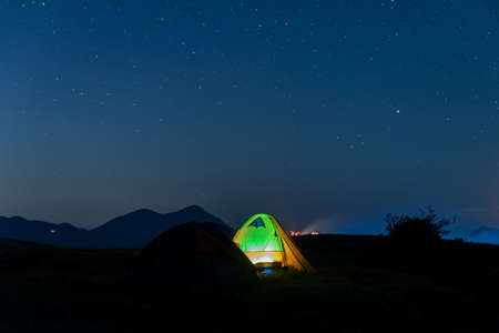 The starry sky at night on the grasslandの写真素材