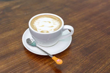 A cup of coffee and milk tea with a picture of a catの写真素材