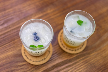 Two white iced drinks with the word "good morning" written on them are on the wooden tableの写真素材
