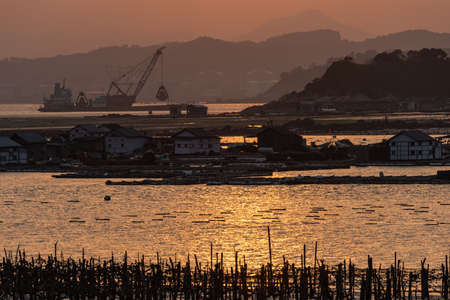 The harbor under the setting sun, the red and round sunの写真素材