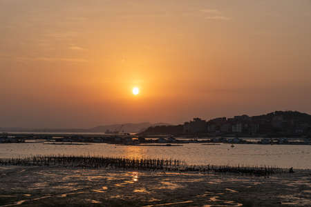 The harbor under the setting sun, the red and round sunの写真素材