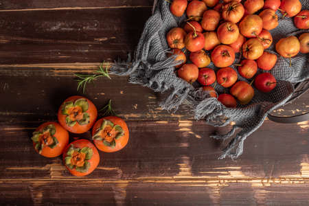 Persimmon and hawthorn are on the wooden tableの写真素材
