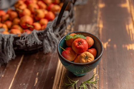 Many colors and varieties of fruit are either on the plate or scattered on the wooden table