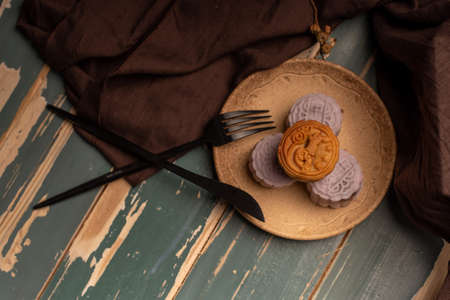 Chinese mooncakes are on the gray cloth of the wooden tableの写真素材