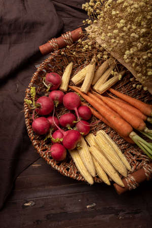 The afternoon sun shines on the red and orange radishes in the basketの写真素材