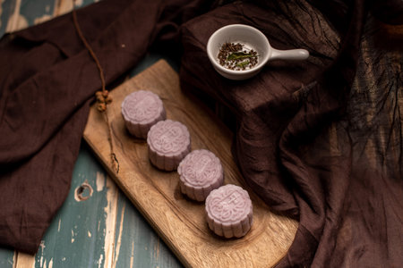Chinese mooncakes are on the gray cloth of the wooden table