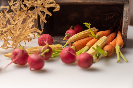 The red and orange radishes are on the white cloth