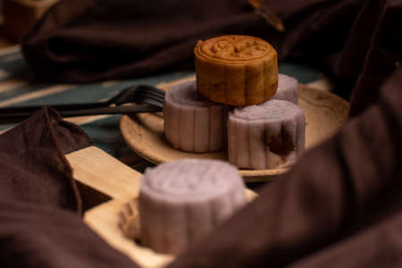 Chinese cakes are on the gray cloth of the wooden tableの写真素材