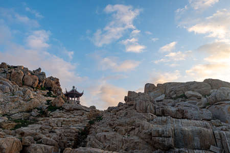 Stones of various shapes weathered by the sea under the blue skyの写真素材