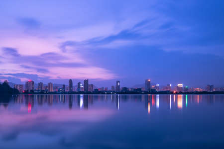 At dusk, the lake reflects the night view of the cityの写真素材