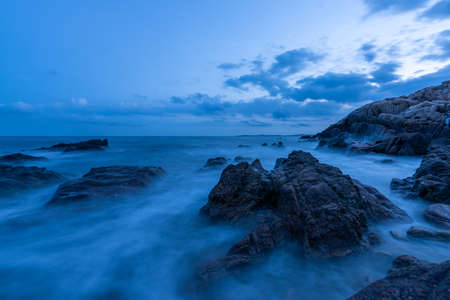 In the evening, the sea slapped the rocksの写真素材