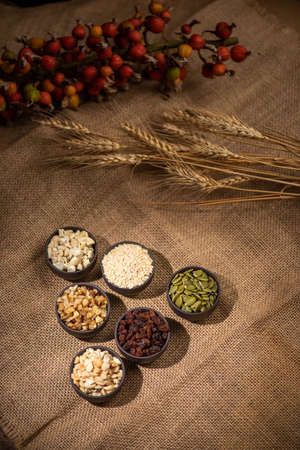 Peanuts, melon seeds, raisins, cashews and walnuts form a geometric shape in a dark backgroundの写真素材