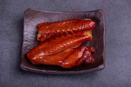 Marinated chicken wings on a plate against a dark backgroundの写真素材