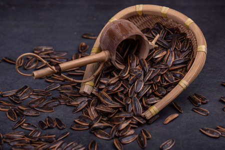 Sunflower seeds in the dark background inside the containerの写真素材