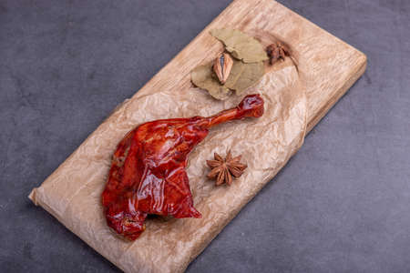 The stewed red chicken legs in the container are in a dark backgroundの写真素材