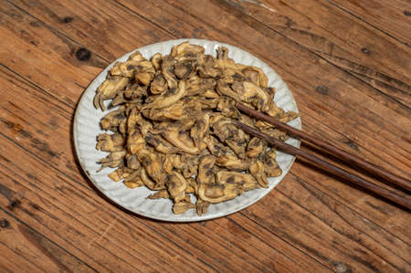 The razor clams in the dishes are dried on the wood grain tableの写真素材