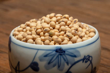 Soybeans placed in a bowl or plate are on the wood grain tableの写真素材