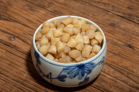 The plates or bowls in the wooden table contain scallopsの写真素材