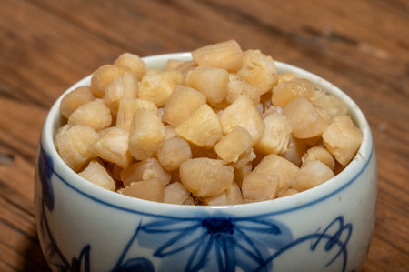The plates or bowls in the wooden table contain scallopsの写真素材