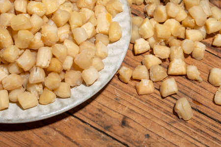 The plates or bowls in the wooden table contain scallopsの写真素材
