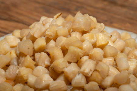 The plates or bowls in the wooden table contain scallopsの写真素材