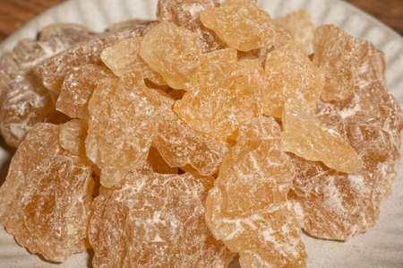The rock sugar in the container is on the wood grain tableの写真素材