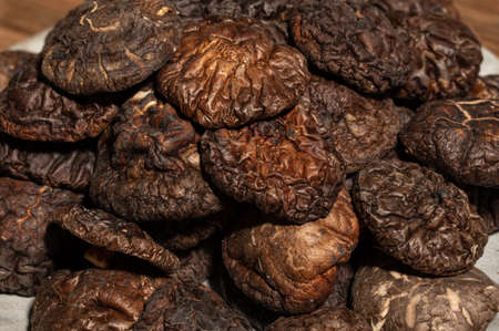 Dried mushrooms in a container on a wooden countertopの写真素材