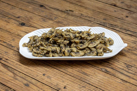 Dried razor clams in containers on wood grain countertopsの写真素材