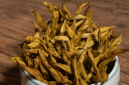 Dried day lily in a container on a wooden countertopの写真素材