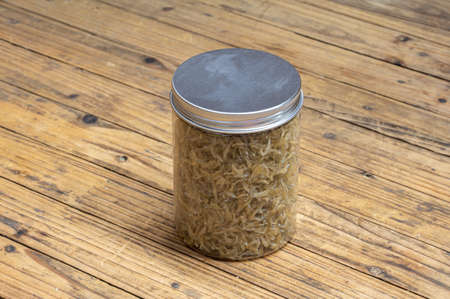 The dried clove fish in the container is on the wood grain tableの写真素材